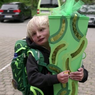 Oskar am Tag der Einschulung mit einer Schultüte. Der sechsjährige Junge hat nur ein halbes Herz.