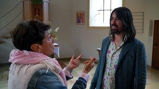 Sonja Faber-Schrecklein wandelt auf den Spuren der Waldenser in Großvillars. In der Kirche redet sie mit Pfarrer Lukas Frei.