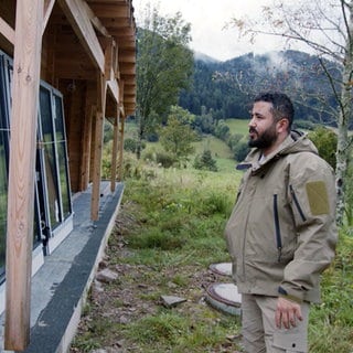 Betab steht vor einem Ferienhäuschen, das auf dem Campingplatz in Wolfach im Schwarzwald neu gebaut wird.