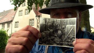 Axel Gagstätter hält Foto von Explosion in Pulvermühle Adolzfurt hoch