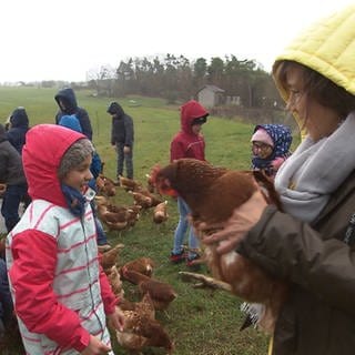 Annette Krause hält ein Huhn auf dem Arm