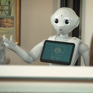 Ein Roboter erklärt etwas vor einem Gemälde