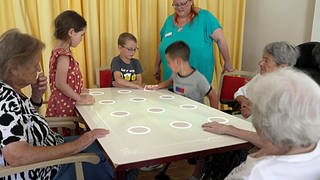 Kita-Kinder spielen mit Senioren im Altersheim