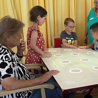 Kita-Kinder spielen mit Senioren im Altersheim