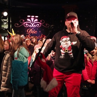 Sänger Bully und die "Coolen Kids" singen zusammen auf dem Mainzer Weihnachtsmarkt.