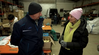 Sarah mit Ukraine-Helfer Markus Schlickat in einer Lagerhalle, wo Sachspenden gelagert und sortiert werden.