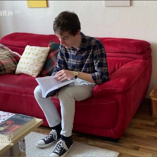 Autor Jonathan Degen blättert in einem Buch