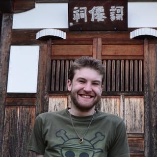 Andreas Becker vor einer Hütte in Japan