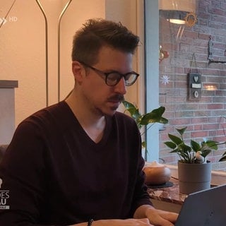 Tim Zwick schreibt am Laptop