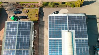 Solaranlagen auf zwei Nutzgebäuden aus der Drohnenperspektive gesehen