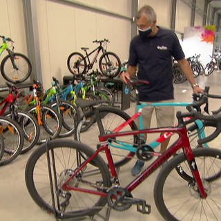 Fahrradhändler stellt Rad in einem Verkaufsraum auf