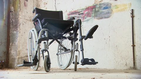 Leerer Rollstuhl steht in einem Kellerraum