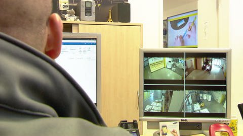 Mitarbeiter beobachtet Monitor mit Kamerabildern der Videoüberwachung im Mainzer Mietlager.