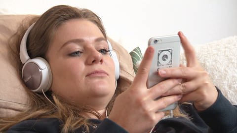 Junge Frau mit Kopfhörer und Handy