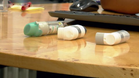 Inhalatoren mit Asthma-Medikamenten liegen auf einer Tischplatte