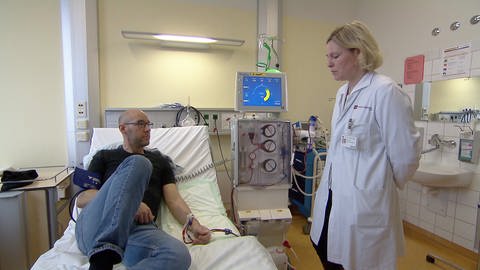 Dialysepatient im Krankenhausbett, Ärztin bei der Visite