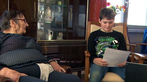 Der 12-jährige Timo Jungen aus Gau-Odernheim liest der 80-jährigen Sieglinde Schmitt vor