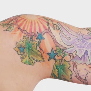 Farbiges Tattoo auf weiblichem Oberarm 