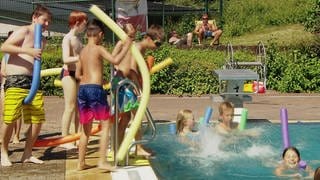 Kinder vergnügen sich im Schwimmbad.  