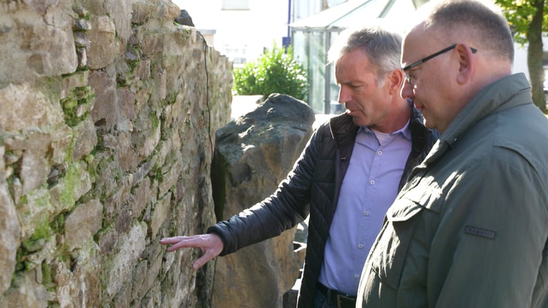 Bernhard Maas und Bürgermeister Norbert Rausch an der alten Stadtmauer