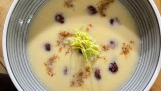 Selleriecremesuppe mit Kirschen, salzigem Walnusskaramell und Lauchstroh.