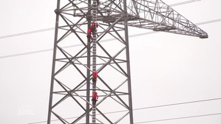 Freileitungsmonteure auf einem Strommast