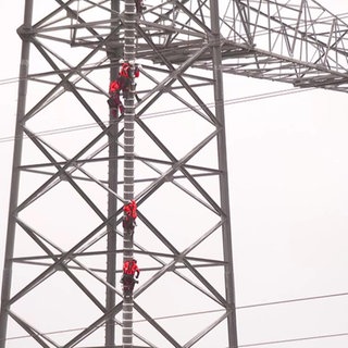 Freileitungsmonteure auf einem Strommast