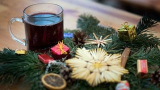 Glühwein im Glas vor Weihnachtsdekoration