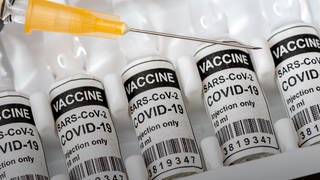 Impfspritze auf Impfstofffläschchen: Die Impfstofflieferungen lassen auf sich warten.