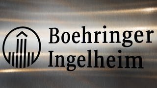 Auf einer Edelstahltafel mit dem Firmenlogo des Pharmakonzerns Boehringer Ingelheim spiegelt die Deckenbeleuchtung. 