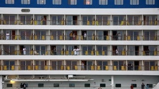 Passagiere stehen auf den Balkonen vom Kreuzfahrtschiff "Aidasol". Als erstes Kreuzfahrtschiff der Saison 2021 in Warnemünde läuft die "Aidasol" in den Seekanal ein.