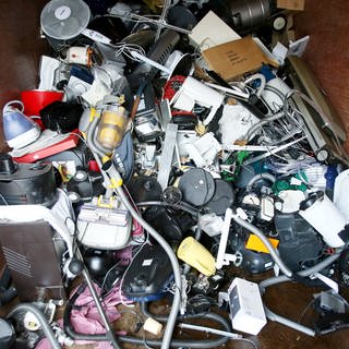 Ausrangierte Haushaltsgeräte und andere Elektrogeräte in einem Sammelbehälter für Elektroschrott: Kleine Haushaltsgeräte können jetzt bei Supermärkten und Discountern zurückgegeben werden.