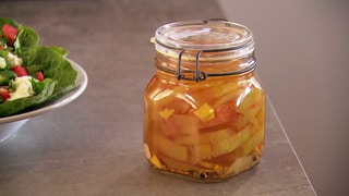 Gelbe Stückchen in orangefarbenem, klaren Sud mit Senfkörnern in Weckglas. Auch Melonenschalen sind essbar: Hier ein Rezept zum Einlegen.