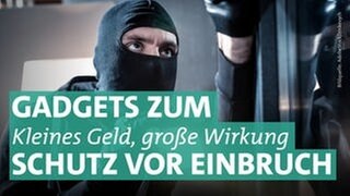 Ein Mann trägt eine schwarze Sturmhaube, die sein Gesicht und Kopf bedeckt. Nur die Augen sind zu sehen. Der Einbrecher ist schwarz gekleidet und hält eine Taschenlampe in seiner rechten Hand. Er befindet sich vor einer Glasscheibe. 