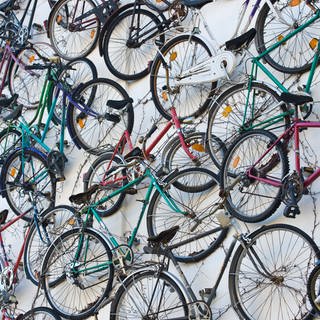 An der Wand hängen viele Fahrräder.