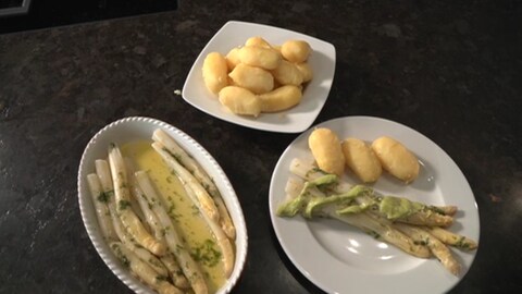 Spargel in Limetten-Minzöl und Avocado-Mayonnaise auf Tellern angerichtet.