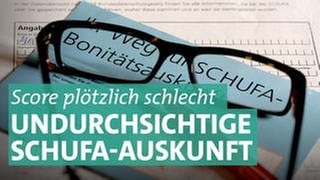 Auf einem Antrag für die Datenkopie der Auskunftei Schufa liegt ein blauer Flyer zum Thema Schufa-Bonitätsauskunft, eine Brille und ein roter Kugelschreiber.