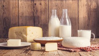 Auf dem Bild sind Milch, Käse und Butter zu sehen. Milchprodukte enthalten wertvolle Inhaltstoffe und werden daher als gesund angesehen. Aber wie viel Milch am Tag ist wirklich gut für Körper und Umwelt? 