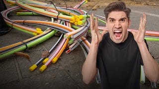 Handwerker verlegen Glasfaser-Kabel für einen Glasfaserausbau. Highspeed-Internet per Glasfaser: Was tun, wenn der Vertrag abgeschlossen oder der Anschluss im Haus liegt - aber dann geht es nicht weiter? 