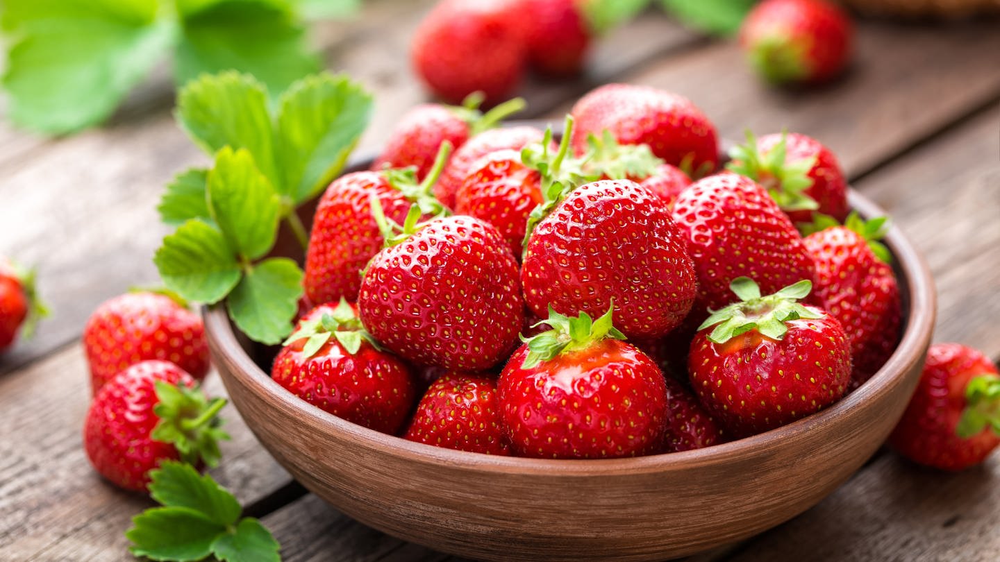 Eine Schale mit Erdbeeren steht auf dem Tisch. Erdbeeren sind gesund und schmecken besonders gut als Kuchen. Aber sie eignen sich auch für herzhafte Rezepte - zum Beispiel im Erdbeer-Spargel-Salat. 