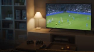 Fernseher in einem Wohnzimmer auf welchem Fußball läuft. TV: Fernseher neu kaufen oder Sound aufrüsten zur EM.