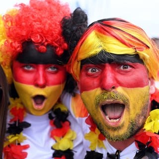 Fußballfans aus Deutschland sind in schwarz-rot-gold angezogen.