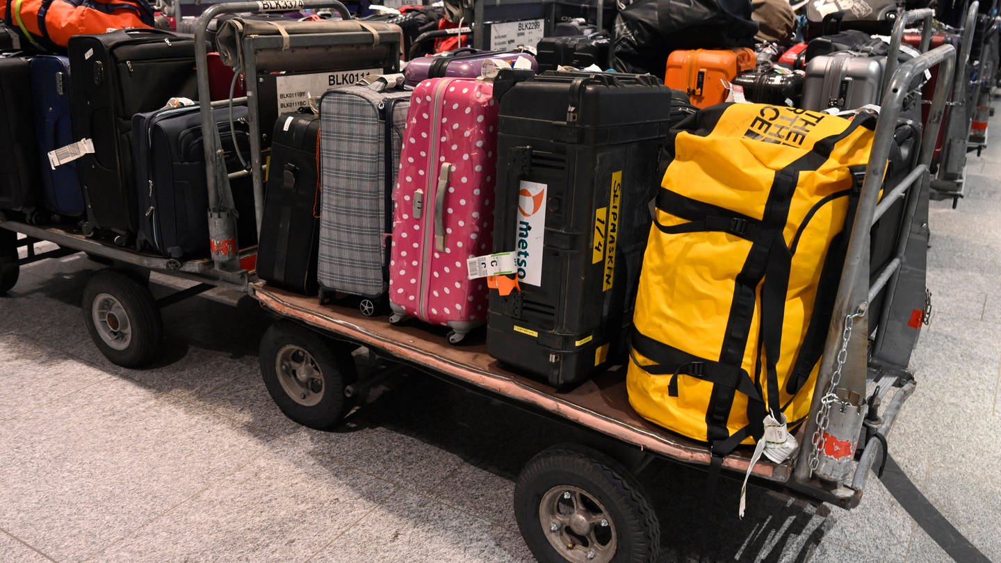 Viele Koffer liegen auf offenen Transportwagen. Gepäck kann auch ohne Urlauber alleine vorfahren: Gepäck vorausschicken - die wichtigsten Tipps für Bahn, Hermes und Tefra