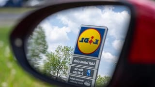 Lidl-Logo in einem Auto-Seitenspiegel. Marktcheck checkt Lidl: Wie gut ist die Qualität, wie günstig ist Lidl und wie steht es um das Tierwohl beim Fleisch?