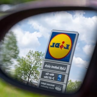 Lidl-Logo in einem Auto-Seitenspiegel. Marktcheck checkt Lidl: Wie gut ist die Qualität, wie günstig ist Lidl und wie steht es um das Tierwohl beim Fleisch?