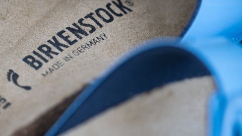 Birkenstock-Modelle stehen vor einem Ladengeschäft des Schuhherstellers. Birkenstock wirbt unter anderem damit, Erfinder des Fußbetts zu sein - internationaler Slogan des Unternehmens ist auch „The Footbed Company“.