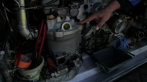 Hand deutet auf Sichtfenster im Heizöl-Tanklaster. Wenn weniger Heizöl im Tank ist, als bezahlt wurde: Betrug bei der Lieferung?