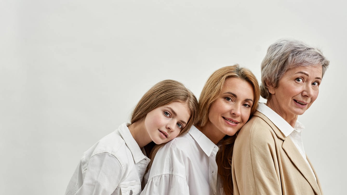 Ein Mädchen lehnt sich an ihre Mutter, diese lehnt sich wiederum an ihre Mutter, die Großmutter des Mädchens. Sie tragen alle weiß, es wirkt friedlich - doch nicht immer laufen Erbfolgen harmonisch ab: Wenn Eltern ihren Kindern nicht ihr komplettes Vermögen vererben wollen oder sogar nur einen Pflichtanteil, können sie dies im Testament festhalten. Hier gibt es einiges zu beachten.