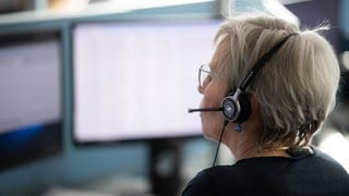 Eine Frau mit Headset sitzt vor zwei Monitoren. Anfang Dezember stellt die Telekom ihre Auskunft ein