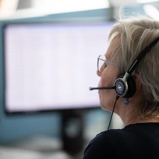 Eine Frau mit Headset sitzt vor zwei Monitoren. Anfang Dezember stellt die Telekom ihre Auskunft ein